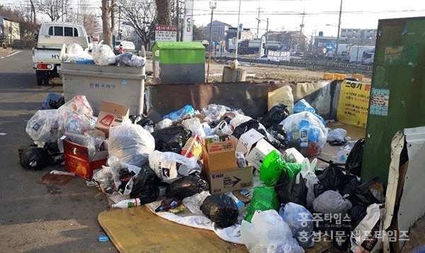홍성읍 남장1구 공터에 분리수거가 되지 않은 채 쓰레기가 가득 쌓여 있다.
