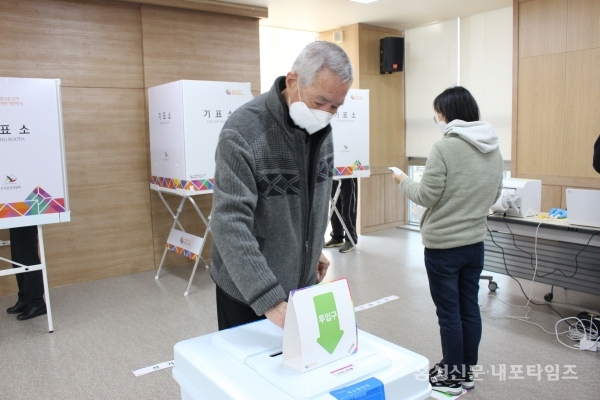 주민이 투표 용지를 투표함에 넣고 있다.