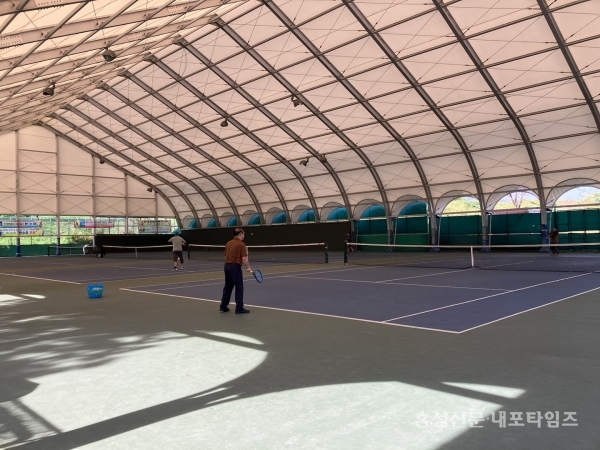 홍주종합경기장에 있는 테니스 경기장. 연습하는 회원들 뒤로 햇볕이 비친다. 경기에 영향을 주기에 가림막 설치는 협회의 최우선 목표 중 하나다.
