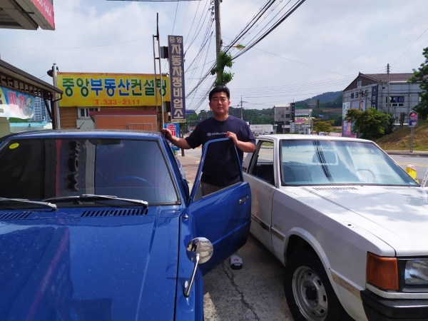 김상국 씨가 그의 포니자동차 2호, 3호를 옆에 서 있다. 흰색의 포니는 최근 예산의 한 폐차장에서 구입했다.